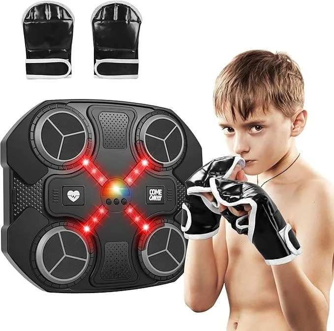 A child wearing black boxing gloves stands next to a wall-mounted interactive music boxing machine with red glowing targets.