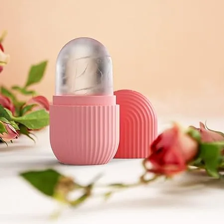 A pink silicone facial ice roller mold placed next to fresh flowers