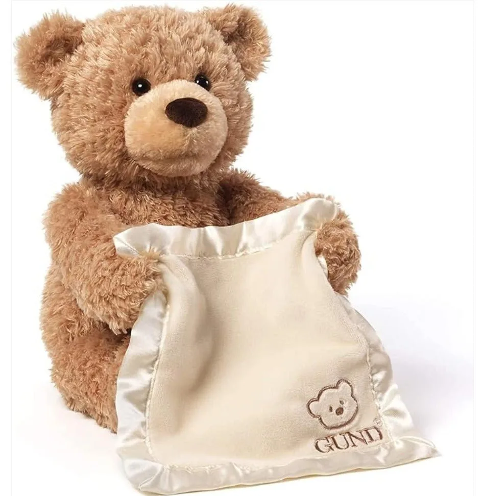 Peekaboo Teddy Bear holding a cream-colored blanket